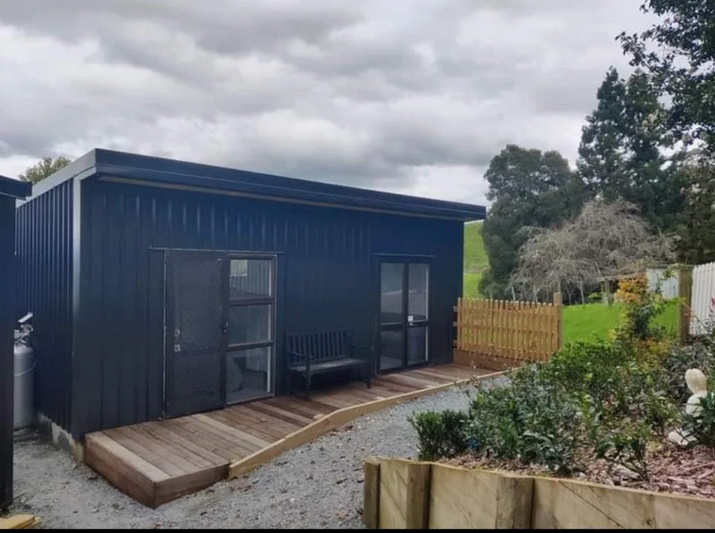 Before and after of a brick home transformation: original brick bungalow above, the same home with a new charcoal metal roof and fresh entry below